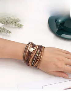 Detail of layered snake pattern leather bracelet with magnetic clasp and gold accents