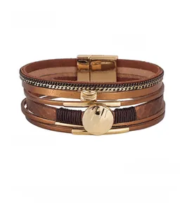 Close-up of multilayer braided leather bracelet with magnetic clasp and rose gold charms