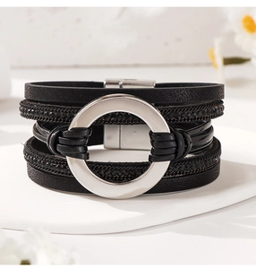 Vista detallada de la pulsera multicapa de cuero negro con anillos plateados y pedrería
