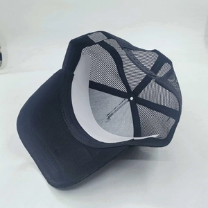 Detail view of black mesh trucker hat interior with adjustable strap and breathable fabric