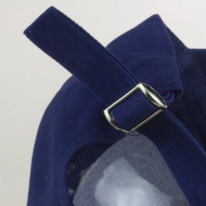 Detail of adjustable cotton strap and silver metal buckle on navy denim baseball cap
