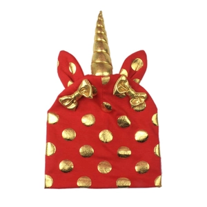 Red knit baby hat with golden unicorn horn and polka dots for festive outfit