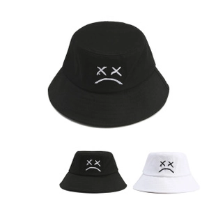 Detailed view of the embroidered face pattern on the crown of a reversible bucket hat