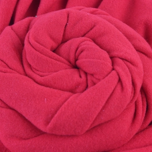 Détail macro du tissu polaire rouge torsadé en forme de fleur, texture douce