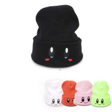 Detail view of colorful knitted beanies with cute cartoon character faces in five colors