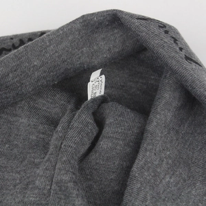 Macro detail of dark gray knit fabric with soft texture and clothing care label