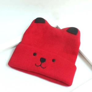 Bonnet en tricot rouge pour bébé avec oreilles d'ours et visage brodé sur blanc