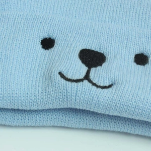 Gros plan sur la maille bleu clair avec broderie mignonne de visage d'ours noir