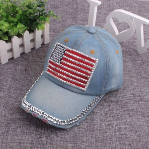 Detail of light blue denim cap featuring American flag rhinestone patch and studded brim