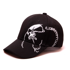 Detailed close-up showing white skull embroidery on black cotton baseball cap
