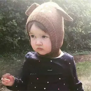 Detail of baby winter knit hat with 3D deer ears design on a toddler model