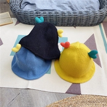 Three children's knitted bucket hats in blue and yellow with colorful 3D heart decorations
