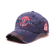 Detail of navy washed cotton baseball cap featuring 3D New York embroidery and leather brim