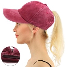 Detail view of burgundy ponytail baseball cap with convenient cutout for high messy buns
