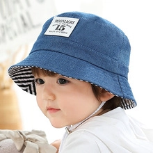 Detail of blue denim bucket hat for kids with adjustable chin strap and striped lining