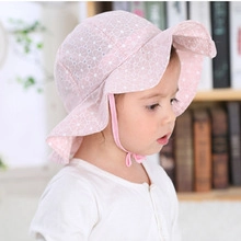 Detail of baby sun hat in pink with white floral embroidery and adjustable chin straps