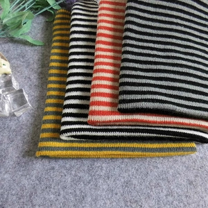 Detailed view of striped knit beanies in multiple colors with soft texture and warm wool