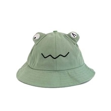 Detail of green frog cotton bucket hat for toddlers featuring cute 3D eyes and smile