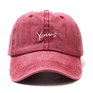 Close-up of Yours embroidery on a vintage washed pink cotton baseball cap