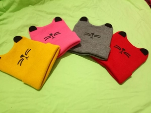Close-up of cute cartoon cat ear knit hats in four colors with embroidered whiskers