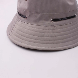 Gros plan du tissu ripstop et du détail de sangle B5 SPIRIT sur un chapeau bob