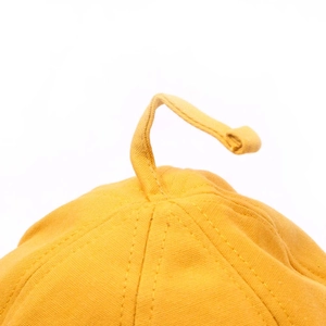 Detailed close-up showing the top stitching and fabric texture of the yellow cotton bucket hat
