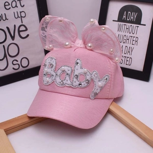 Dettaglio cappello baseball rosa per bambina con fiocco di pizzo, perle e ricamo Baby
