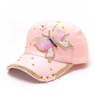 Détail de la casquette rose avec papillon à paillettes, perles et anneaux métalliques