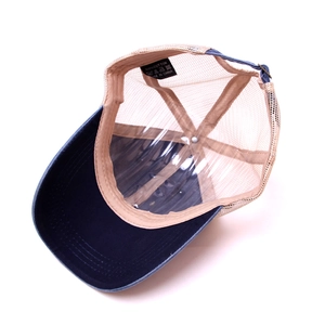 Detail view of cotton trucker hat interior with mesh back and adjustable metal buckle