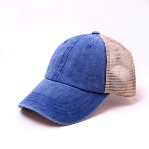 Detail of washed denim trucker hat featuring breathable mesh back and blue visor