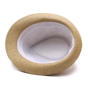 Detailed interior of a woven straw fedora hat featuring a wide white sweatband and texture