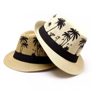 Detail view of woven straw hats featuring palm tree prints and stylish black ribbon bands