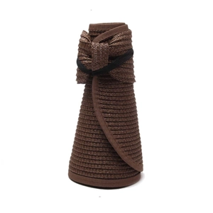 Detail of a foldable dark coffee straw sun hat with fine texture and bow decoration