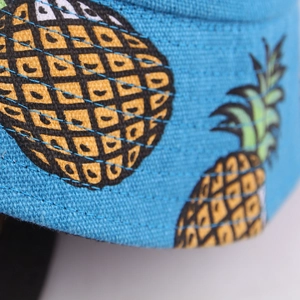 Detailed close-up of dark blue canvas bucket hat featuring vibrant yellow pineapple prints