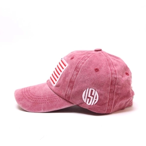 Detail of vintage washed red baseball cap with side USA embroidery and stripe pattern