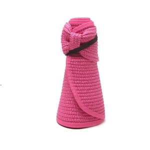 Detail of a foldable pink straw sun hat showing the rolled storage design and woven texture