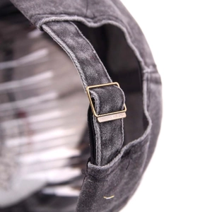 Detail of vintage washed gray cotton baseball cap featuring adjustable metal buckle