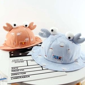 Dettaglio di cappello da sole bimbo con occhi di granchio 3D e motivo rosa e blu