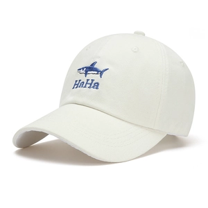 Detailed close-up of blue shark and HaHa embroidery on the white cotton baseball cap