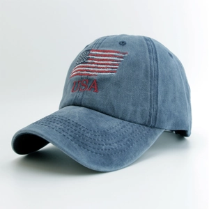 Detail of USA flag embroidery and red lettering on washed blue cotton baseball cap