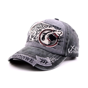 Close-up of shark embroidery and distressed details on washed denim baseball cap