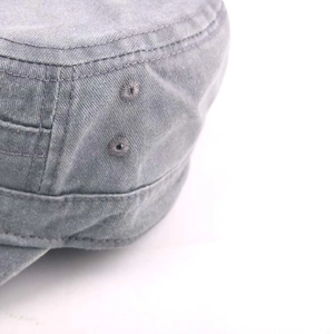 Detail view of washed grey cotton flat top cap showing embroidered eyelets and stitching