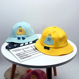 Dettaglio di cappelli da sole per neonati in verde menta e giallo con ricamo a giraffa