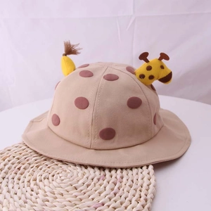Dettaglio delle orecchie di giraffa e pois marroni sul cappello a secchiello in cotone beige
