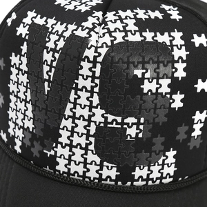 Detailed macro view of black mesh trucker hat with puzzle patterned V8 graphic print