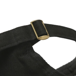 Detail of adjustable metal buckle and stitching on black cotton baseball cap back
