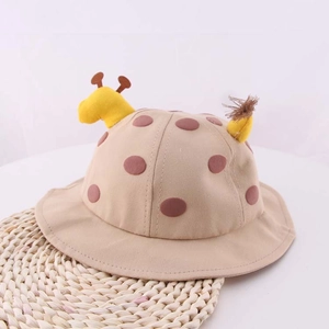 Dettaglio di cappello da sole per neonati con corna di giraffa e pois marroni beige