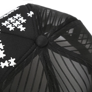Close-up of black mesh truck cap showing breathable fabric and top button detail