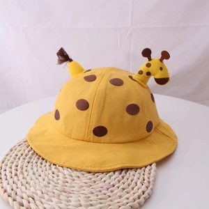 Dettaglio di un cappello da sole giallo per neonati con pois marroni e design giraffa 3D
