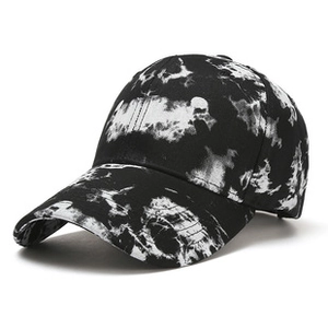 Detailed close-up of a black and white tie-dye street style baseball cap with curved brim